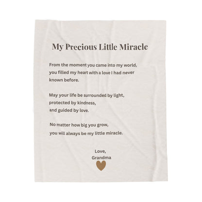 Blanket with a message from a grandma to her child, featuring text and a heart symbol on a cream background.