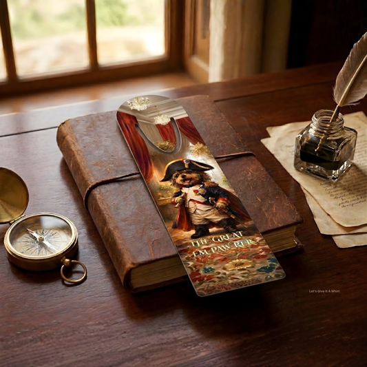 Vintage book with a decorative bookmark featuring a tiny Emperor illustration, surrounded by an inkwell and compass on a wooden surface.